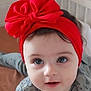 baby, child, face, headband, red_bow, eyes, infant, cute, portrait, bed, bedding, clothing, expression, skin, hair, indoors, person, young, smile, closeup