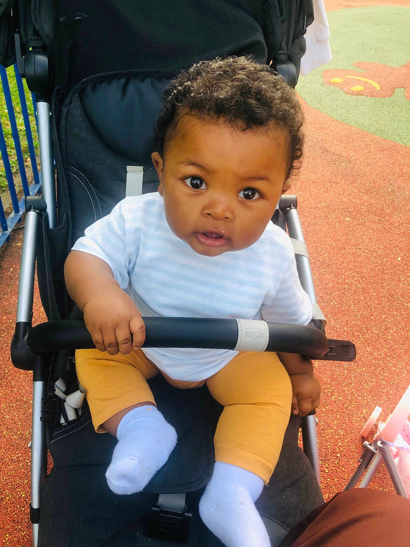 Mselam participe au concours pour gagner de l'argent avec cette photo : baby, child, stroller, outdoor, curious, infant, playground, person, clothing, socks, pants, shirt, hand, face, eyes, hair, seat, toy, play_area, daytime