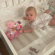 Lya participe au concours pour gagner de l'argent avec cette photo : baby, bed, blanket, child, crib, cute, floor, furniture, indoor, infant, looking_up, lying_down, mobile, patterned_blanket, person, playtime, sleepwear, soft_toys, toy, wooden_floor