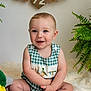 baby, child, smiling, sitting, plush_toy, duck, greenery, plant, basket, indoor, cute, portrait, happy, checkered_clothing, embroidery, fluffy_rug, infant, blue_eyes, soft_lighting, home_decor