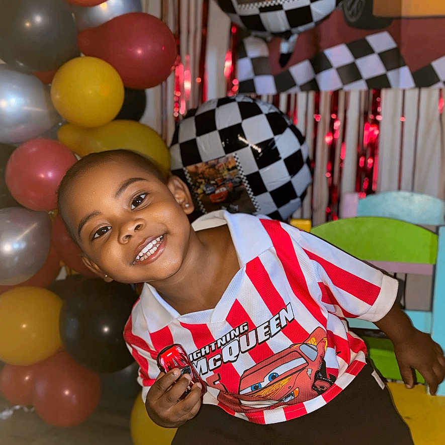 Cymbian joined the competition — help win amazing prizes! child, boy, smiling, balloons, birthday_party, chair, lightning_mcqueen, red_and_white_stripes, checkered_pattern, toy_car, indoor, celebration, happy, decorations, colorful, young_child, casual_clothing, posing, event, fun