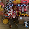 Cymbian is registered to the contest to win money with this photo: child, smile, balloons, birthday, party, chair, toys, decorations, indoor, happy, celebration, car_theme, checkered_flag, colorful, red, yellow, black, floor, person, plush