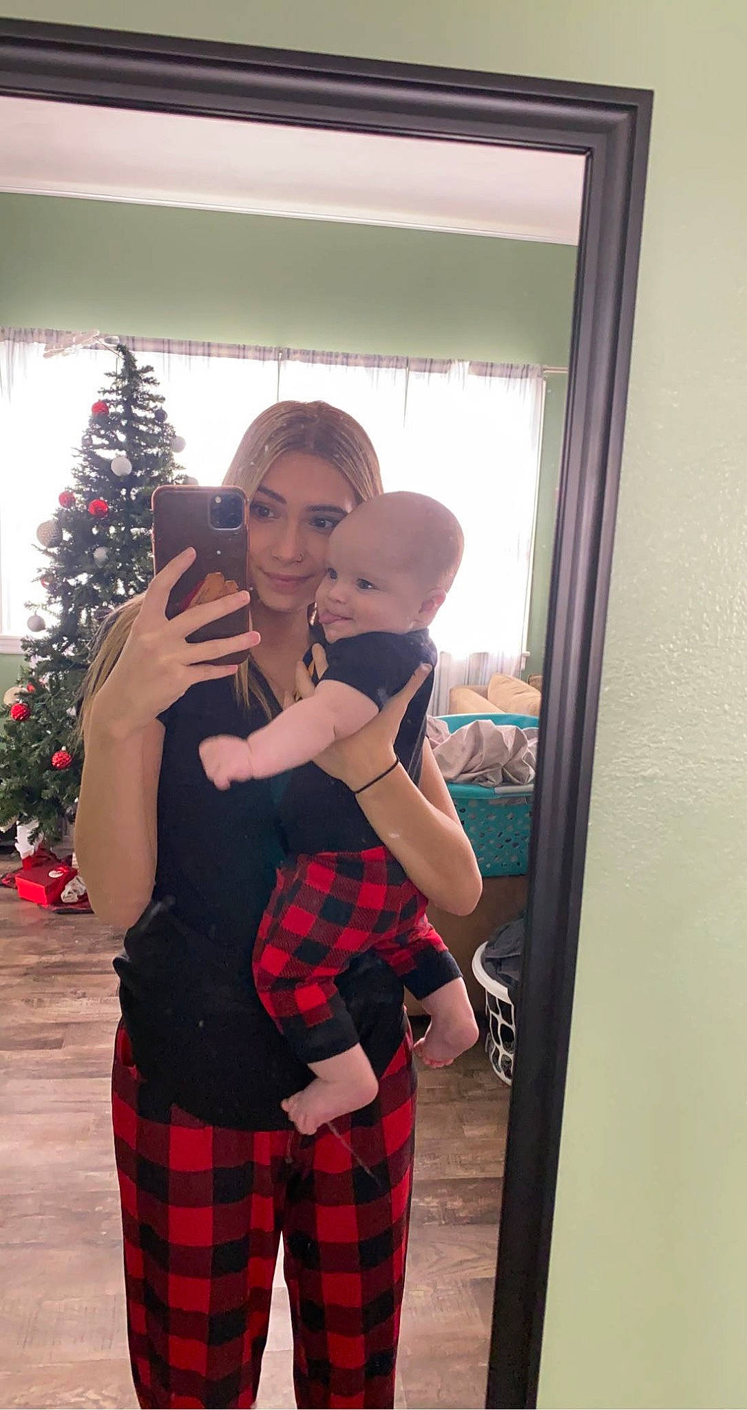 River is registered to the contest to win money with this photo: abdomen, christmas_decoration, christmas_ornament, christmas_tree, door, event, formal_wear, fun, fur, holiday, joy, ornament, pattern, person, plaid, room, standing, sunglasses, tartan, tree