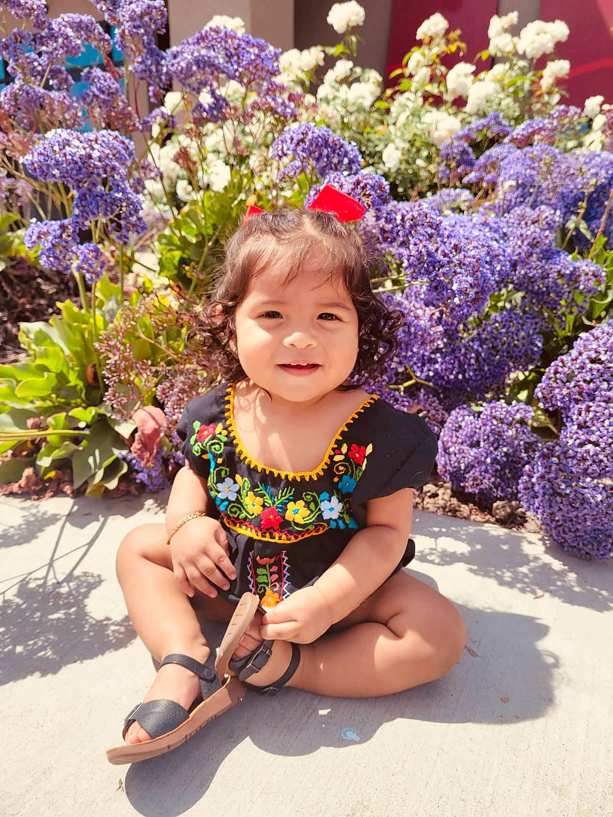 Xiomara is registered to the contest to win money with this photo: baby_toddler_clothing, botany, electric_blue, flower, flower_arranging, grass, happy, iris, joy, magenta, nature, people_in_nature, person, petal, photograph, pink, plant, purple, sandal, smile