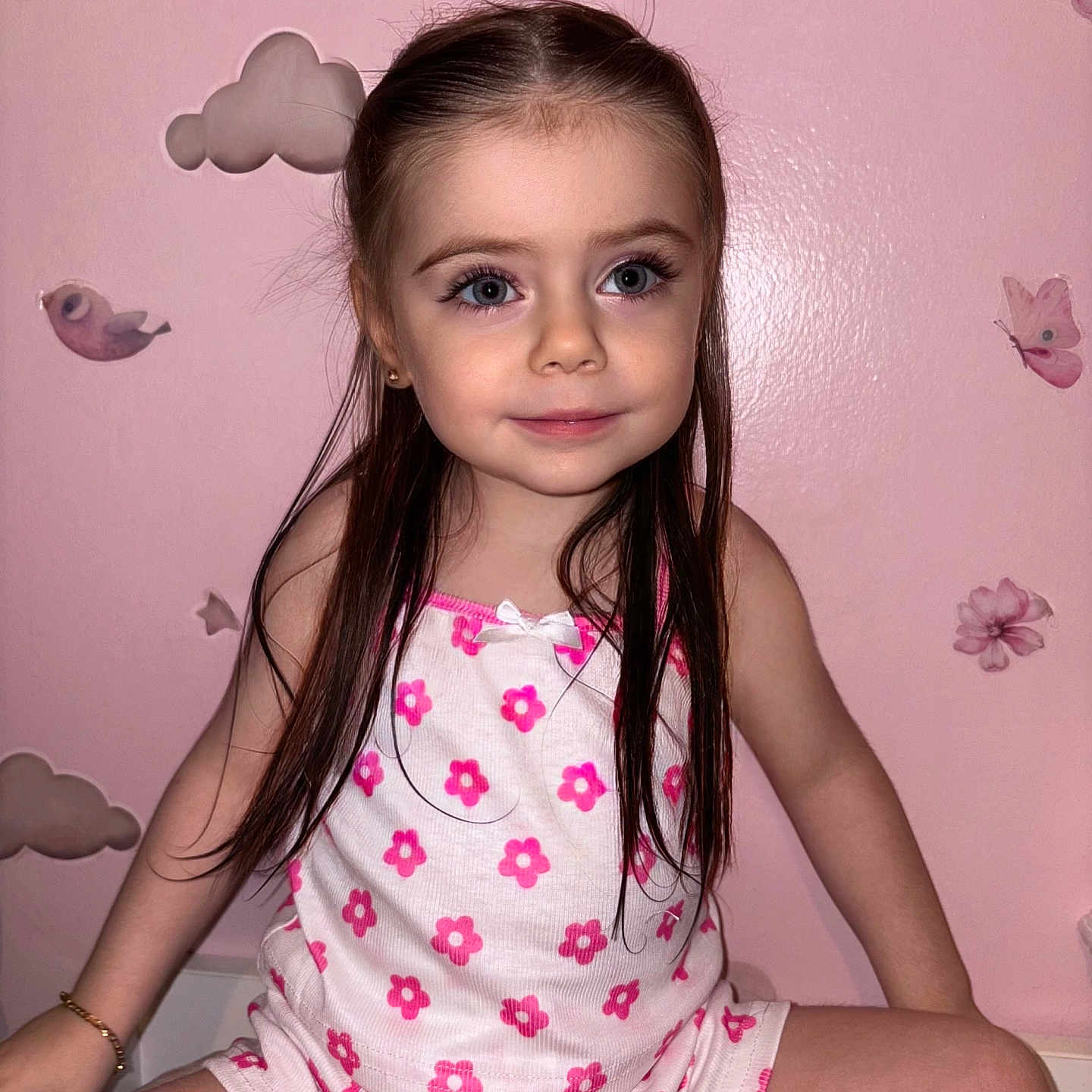 Kayla participe au concours pour gagner de l'argent avec cette photo : bracelet, butterfly_stickers, casual_clothing, child, cloud_stickers, cute, flower_pattern, girl, happy, indoor, long_hair, pink_flowers, pink_wall, portrait, posing, sitting, smiling, wall_decor, white_outfit, young_child