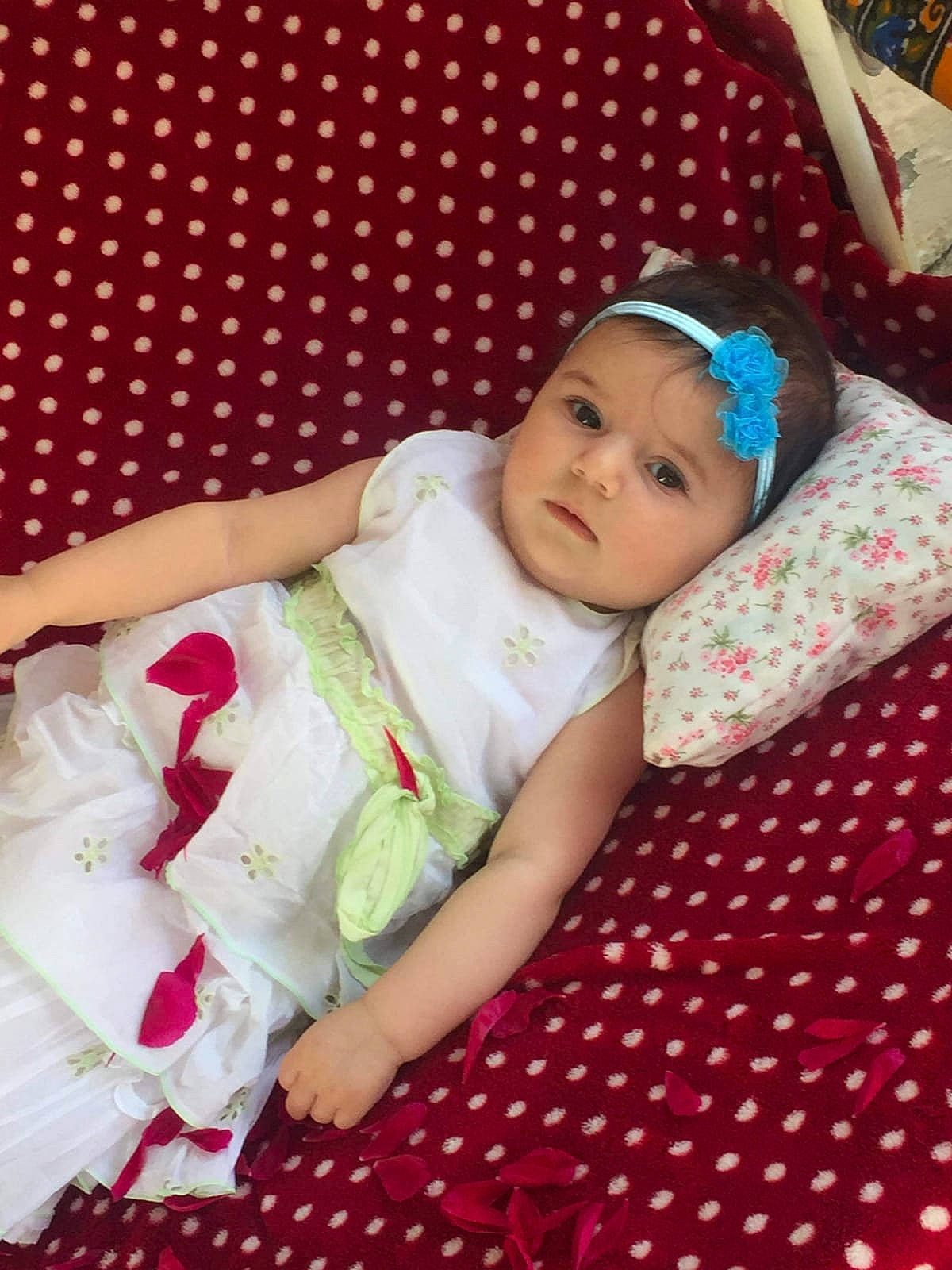 Vanessa participe au concours pour gagner de l'argent avec cette photo : baby, baby_products, baby_toddler_clothing, cap, cheek, child, comfort, fun, happy, headwear, linens, pattern, person, pink, plaid, room, sitting, skin, sleeve, smile