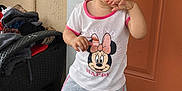 Génesis joined the competition — help win amazing prizes! toddler, child, standing, minnie_mouse, clothing, shorts, tshirt, shoes, door, outdoor, pavement, curly_hair, hand, face, expression, casual, young, person, looking_away, footwear