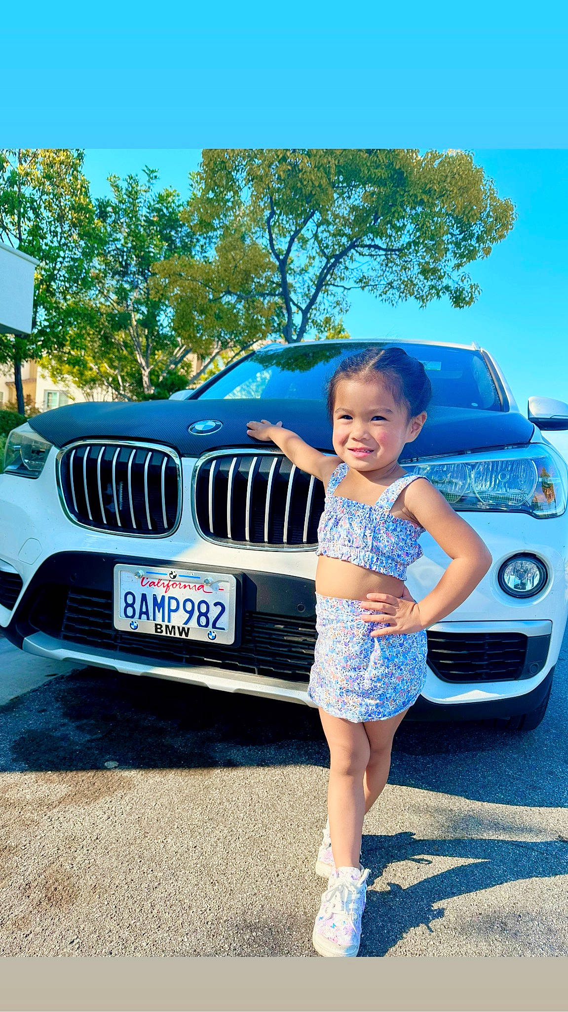 Keziah is registered to the contest to win money with this photo: automotive_design, automotive_exterior, automotive_lighting, automotive_tire, blue, bumper, car, grille, hood, joy, motor_vehicle, person, personal_luxury_car, photograph, rim, shorts, sky, tire, tree, vehicle