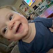 William joined the competition — help win amazing prizes! toddler, smiling, child, blue_shirt, living_room, television, cartoon, couch, furniture, happy, face, person, indoor, home, blur, playful, young_child, casual, family, relaxing