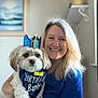 Ganymede joined the competition — help win amazing prizes! woman, dog, birthday, crown, bandana, smile, indoor, blond_hair, pet, celebration, portrait, happy, blue_shirt, white_dog, furry, face, person, sitting, home, decor