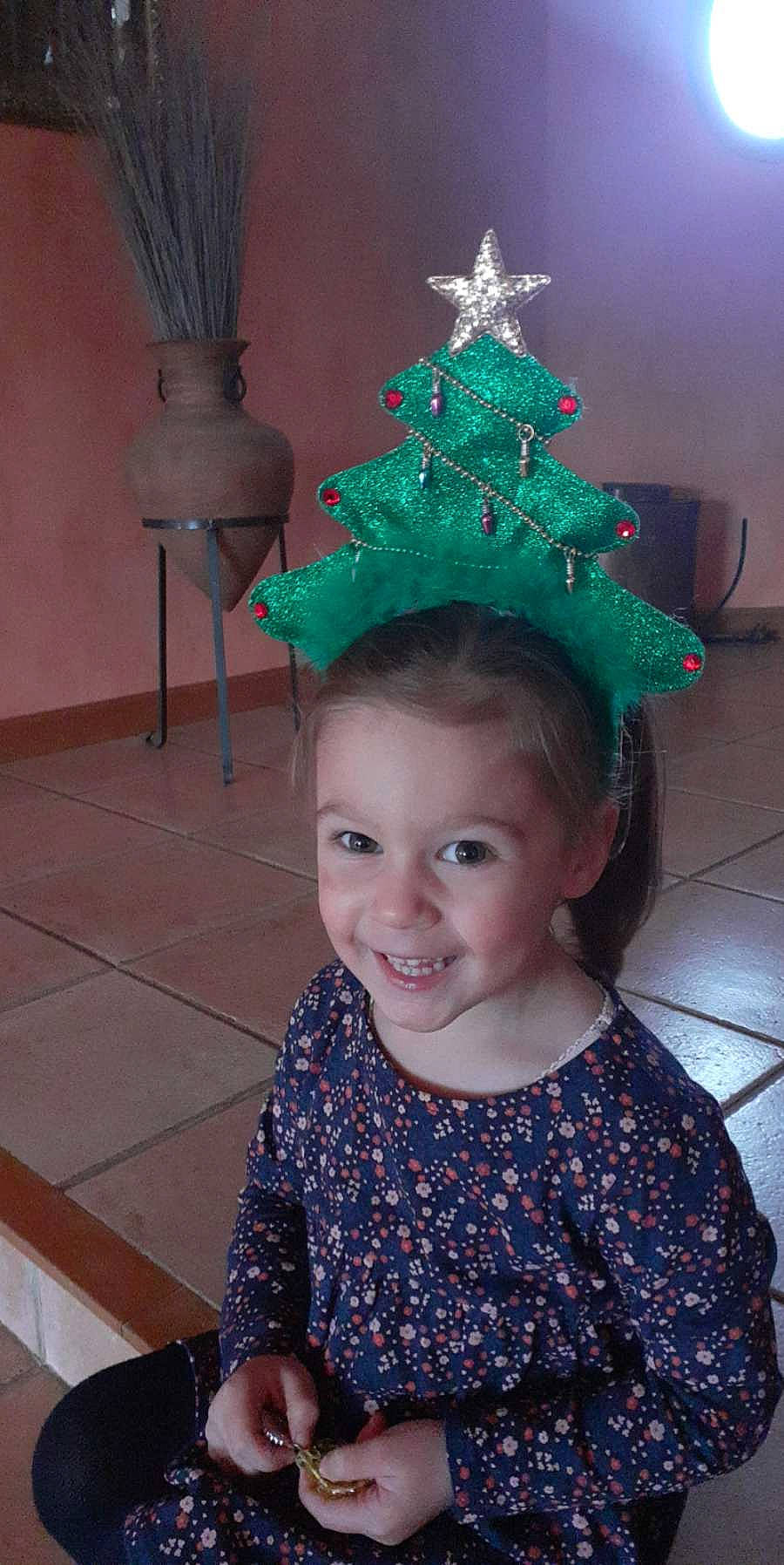 Eden participe au concours pour gagner de l'argent avec cette photo : christmas, christmas_decoration, christmas_ornament, christmas_tree, cone, costume_hat, event, face, fashion, fun, hair_accessory, hairstyle, happy, hat, headgear, headpiece, holiday_ornament, joy, party_hat, person