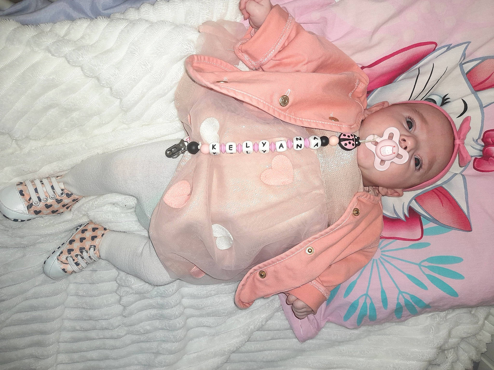 Kélyana a rejoint le concours — aidez-le/la à gagner de superbes lots ! art, baby, baby_products, baby_toddler_clothing, chest, child, comfort, fictional_character, flesh, gesture, happy, human_leg, nail, pattern, peach, person, pink, room, stomach, thigh