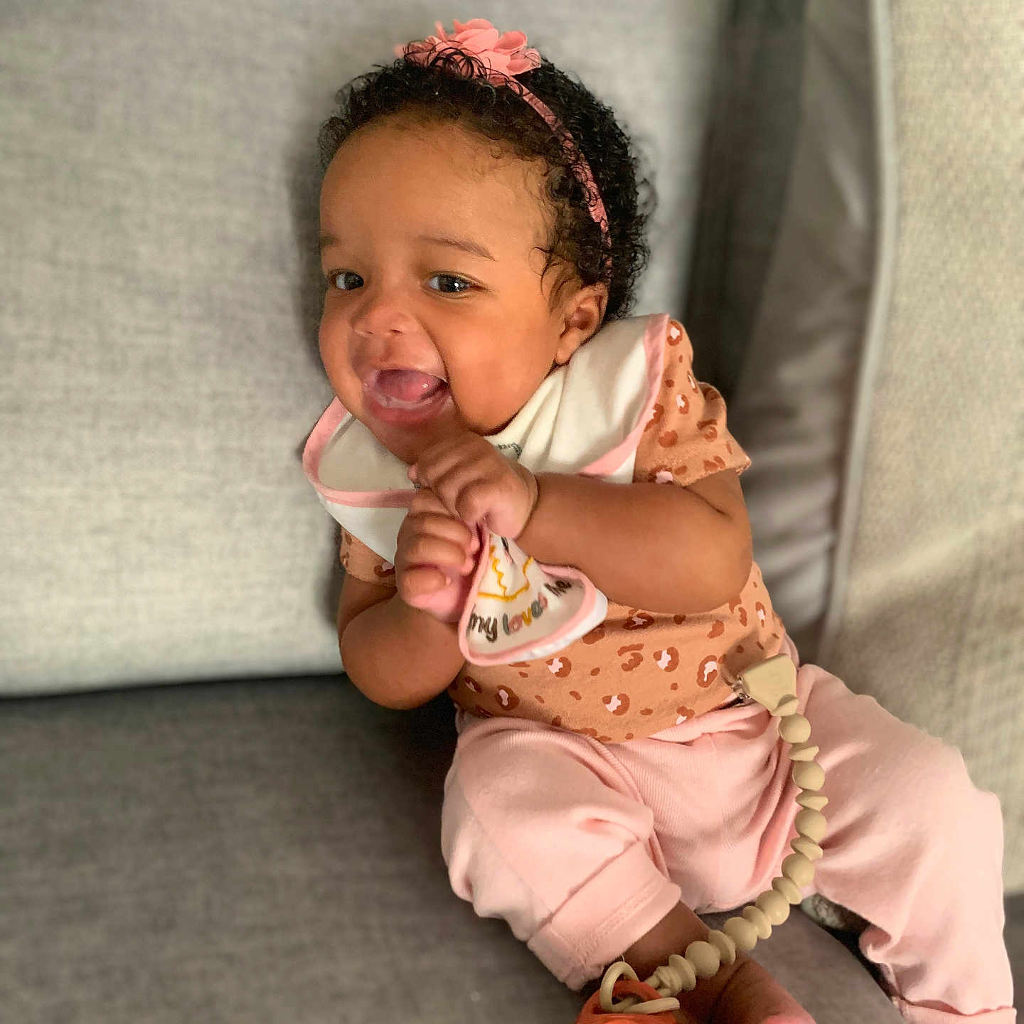 Adria joined the competition — help win amazing prizes! accessories, baby, babylaughing, bodypart, clothing, couch, dress, face, finger, furniture, happy, head, jewelry, laughing, necklace, person, photography, portrait, sitting, smile