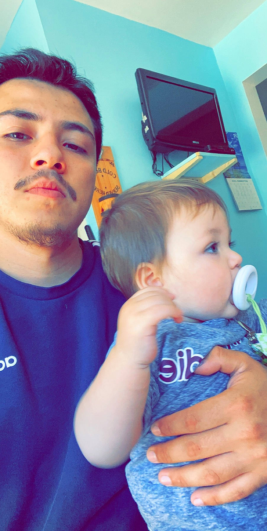 Santiago is registered to the contest to win money with this photo: baby_toddler_clothing, beard, cheek, child, cool, display_device, ear, eye, eyelash, facial_hair, finger, forehead, hairstyle, hand, iris, mammal, nail, organ, person, picture_frame