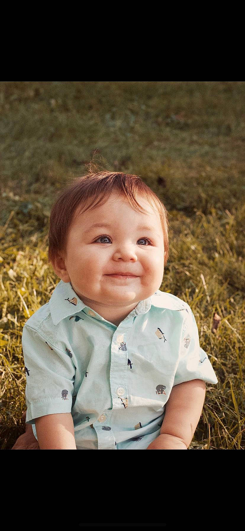 Santiago is registered to the contest to win money with this photo: baby, baby_toddler_clothing, brown_hair, cheek, child, clothing, facial_expression, field, forehead, grass_family, happy, human, iris, joy, lip, mouth, nose, person, prairie, skin