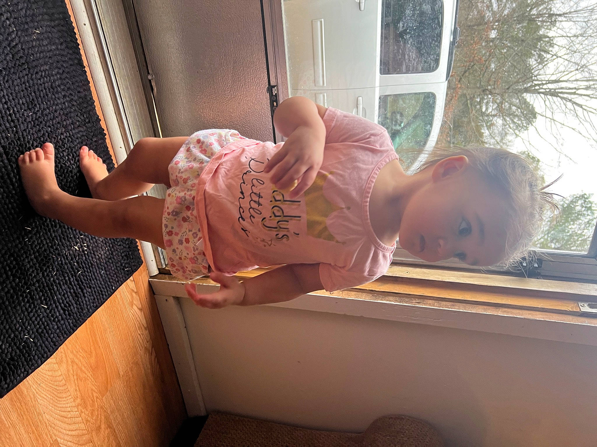 Evailiah is registered to the contest to win money with this photo: comfort, dress, elbow, finger, glasses, hand, house, human_body, human_leg, leg, long_hair, orange, person, plant, sunglasses, thigh, toddler, tree, waist, window
