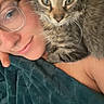 Zelda is registered to the contest to win money with this photo: person, cat, kitten, glasses, blanket, snuggling, face, fur, tabby, indoor, selfie, cute, pet, cozy, closeup, comfort, young_adult, relaxed, resting, portrait