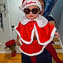 Haisley joined the competition — help win amazing prizes! baby, child, christmas, holiday, festive_clothing, red_cape, santa_hat, sunglasses, heart_shaped, indoor, person_holding, wooden_floor, door, curtains, stairs, plant, home, portrait, cute, smiling