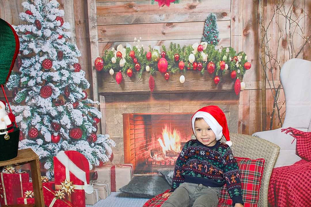 Tiago participe au concours pour gagner de l'argent avec cette photo : christmas_decoration, christmas_eve, christmas_ornament, christmas_tree, event, fireplace, gas, headwear, hearth, holiday, joy, lighting, living_room, ornament, person, plant, property, red, smile, snapshot