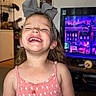 child, girl, smiling, laughing, bow, headband, pink_dress, indoors, television, colorful, living_room, happy, cute, portrait, person, home, fun, young_child, casual, bright