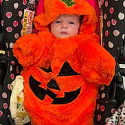 Kaliyah is registered to the contest to win money with this photo: baby, pumpkin_costume, orange, stroller, polka_dot, infant, cute, halloween, costume, child, plush, seat, pattern, face, hood, leaf, black, pink, white, expression