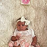 baby, infant, girl, headband, bow, pink, dress, milestone_card, fluffy_rug, soft_texture, cute, portrait, sitting, indoors, young_child, child, people, person, laying_down, adorable