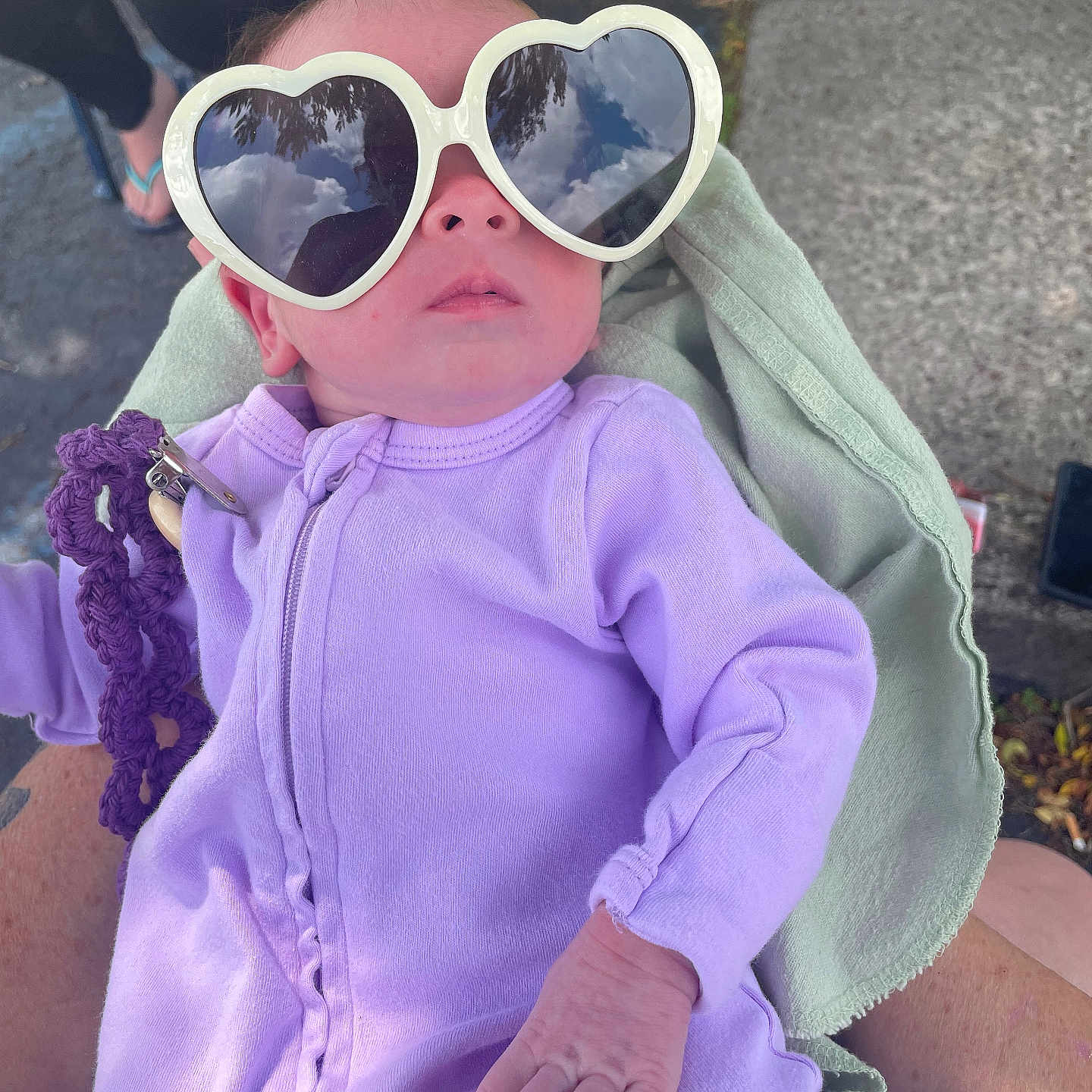 Ahvi is registered to the contest to win money with this photo: baby, blanket, casual, child, cute, fabric, hand, heart_shaped_glasses, holding, infant, lavender_clothing, outdoor, person, portrait, purple, reflection, relaxed, sunglasses, sunny, tattoo