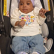 Gazzelle is registered to the contest to win money with this photo: baby, child, infant, car_seat, headband, purple, clothing, floral, shirt, denim, pants, socks, footwear, indoors, seat, safety, smile, portrait, cute, young