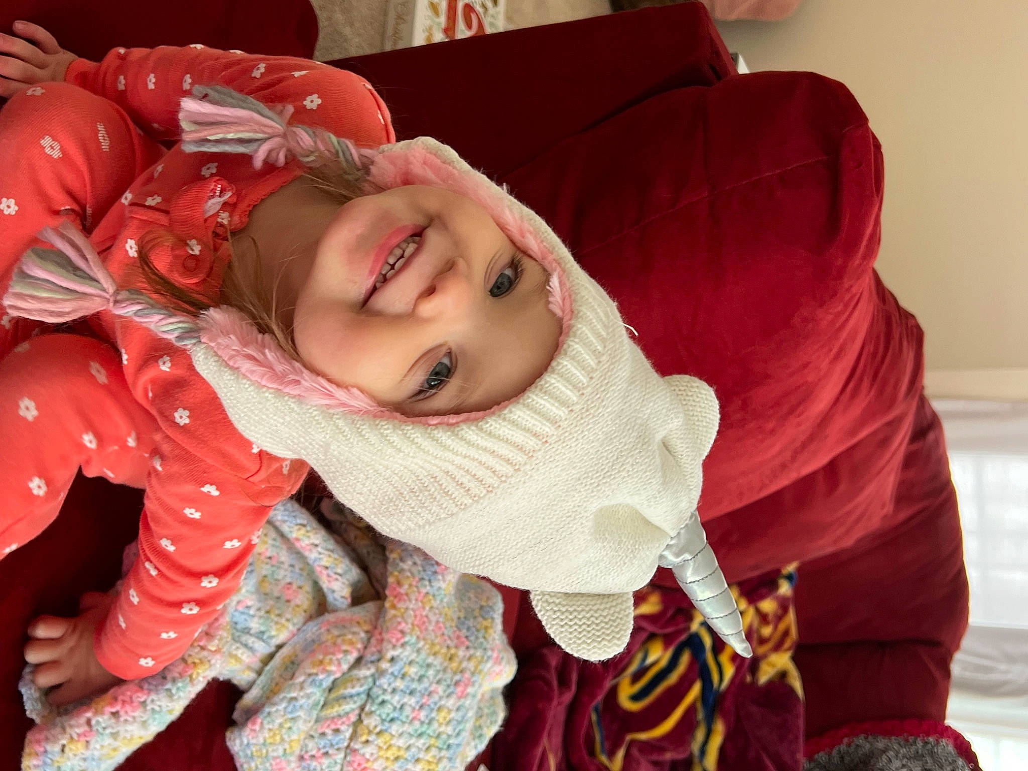 Elianna is registered to the contest to win money with this photo: baby, child, comfort, event, eye, facial_expression, fun, happy, head, headgear, headwear, human_body, joy, lip, mouth, person, shawl, skin, sleeve, smile