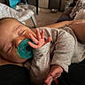 baby, sleeping, pacifier, hand, gray_clothing, infant, cozy, resting, indoor, person, newborn, closeup, cute, peaceful, child, soft_light, home, blanket, relaxing, portrait