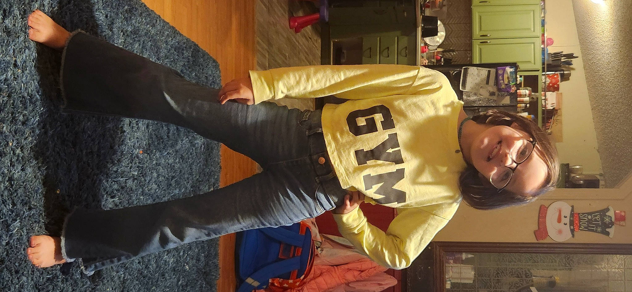 Skylar is registered to the contest to win money with this photo: costume, elbow, flooring, fun, fur, human_leg, joy, person, room, shelf, sleeve, smile, sportswear, t_shirt, thigh, wood