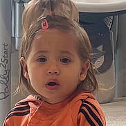 Lana a rejoint le concours — aidez-le/la à gagner de superbes lots ! toddler, child, indoor, orange_jacket, hair_clip, surprised, face, person, young_child, expression, cute, cartoon_background, toy, floor, hair, clothing, closeup, portrait, young_person, casual
