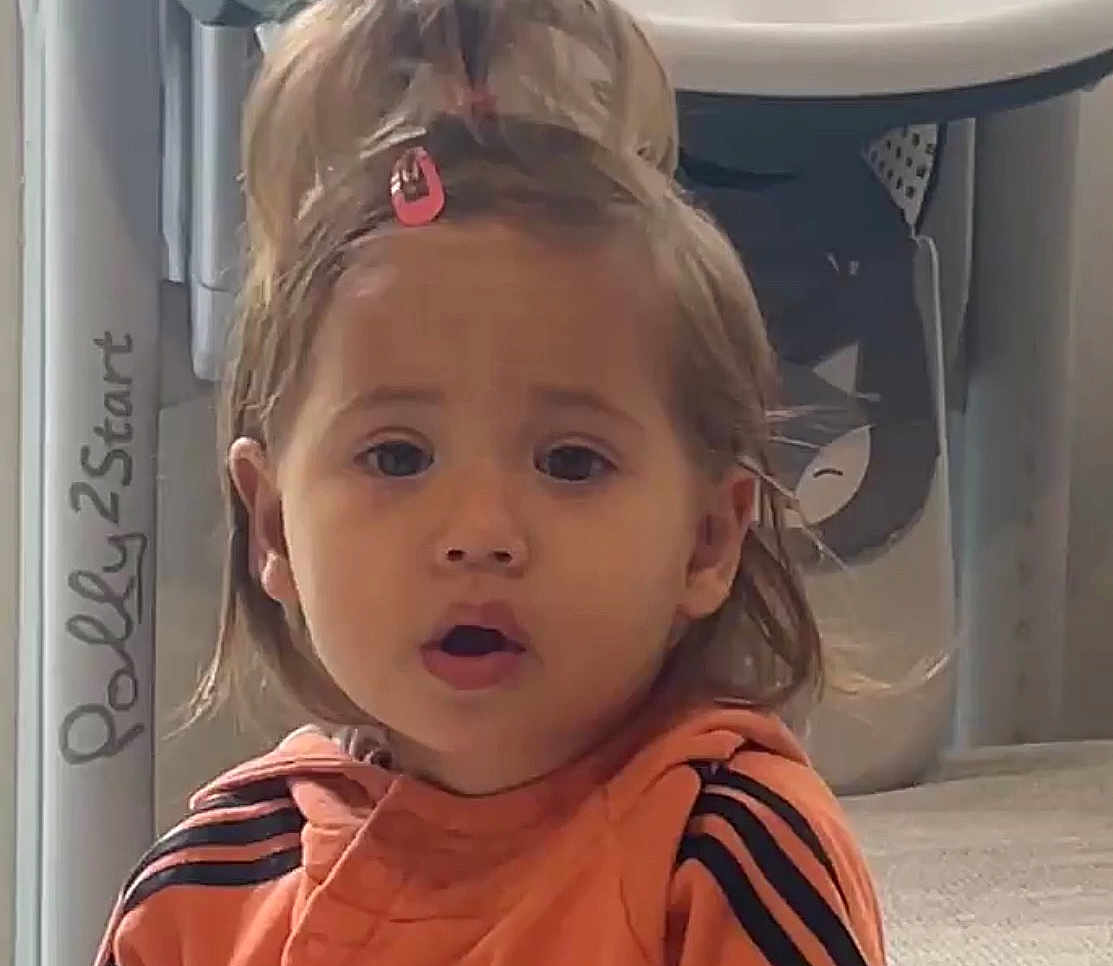 Lana a rejoint le concours — aidez-le/la à gagner de superbes lots ! toddler, child, indoor, orange_jacket, hair_clip, surprised, face, person, young_child, expression, cute, cartoon_background, toy, floor, hair, clothing, closeup, portrait, young_person, casual
