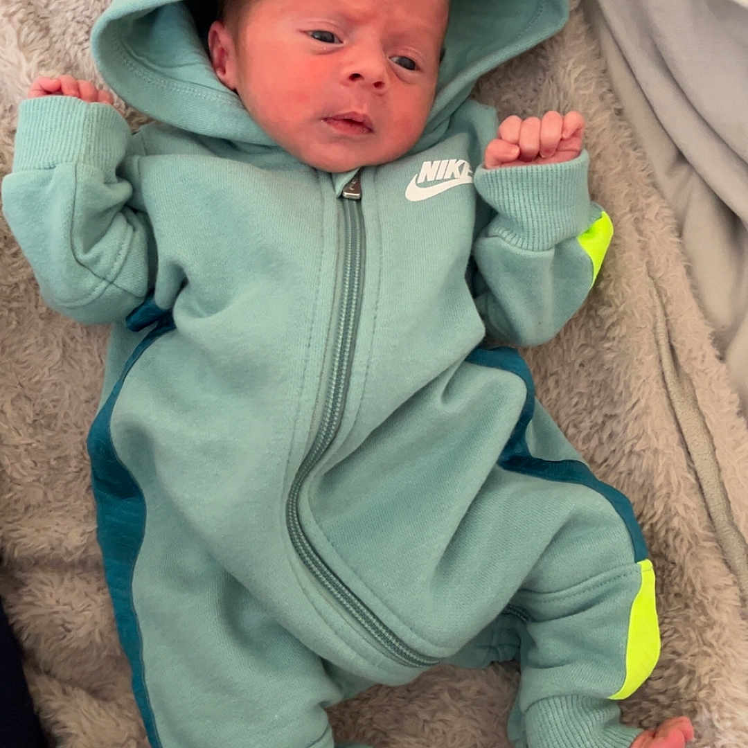 Brodie-Lee joined the competition — help win amazing prizes! baby, blanket, child, clothing, cozy, cute, fabric, face, feet, hands, hoodie, indoor, infant, lying_down, newborn, nike, person, portrait, sleepwear, soft