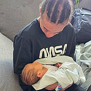 Matteo is registered to the contest to win money with this photo: newborn, baby, person, child, braids, hair, blanket, couch, indoor, love, family, holding, toddler, sleeping, casual, clothing, portrait, cozy, rest, comfort