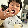 baby_food, bib, candid, cat_bib, child, close_up, cute, eating, face, food, hand, ice_cream, indoor, kitchen, messy, messy_face, portrait, snack, teddy_bear, toddler