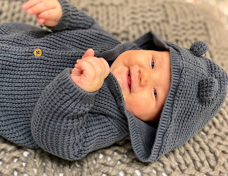 Syrus Jo is registered to the contest to win money with this photo: baby, baby_toddler_clothing, cap, child, comfort, finger, gesture, grey, headgear, headwear, knit_cap, outerwear, pattern, person, skin, sleeve, textile, thumb, toddler, wood