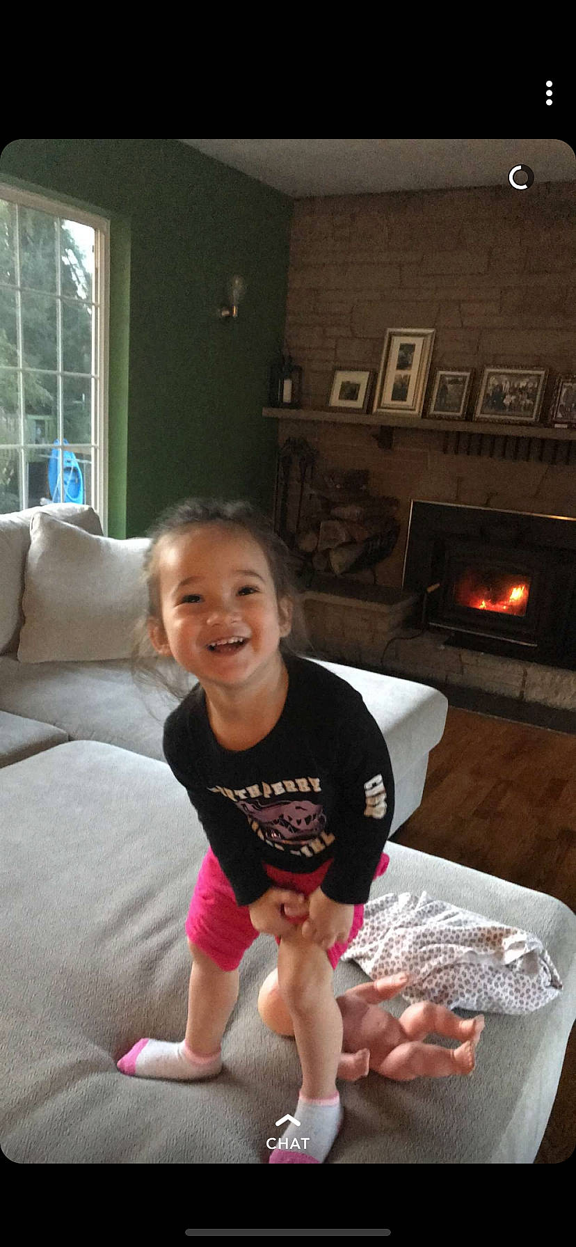 Olive is registered to the contest to win money with this photo: child, electronic_device, fun, furniture, joy, leg, person, room, smile, sportswear, summer, toddler, vacation