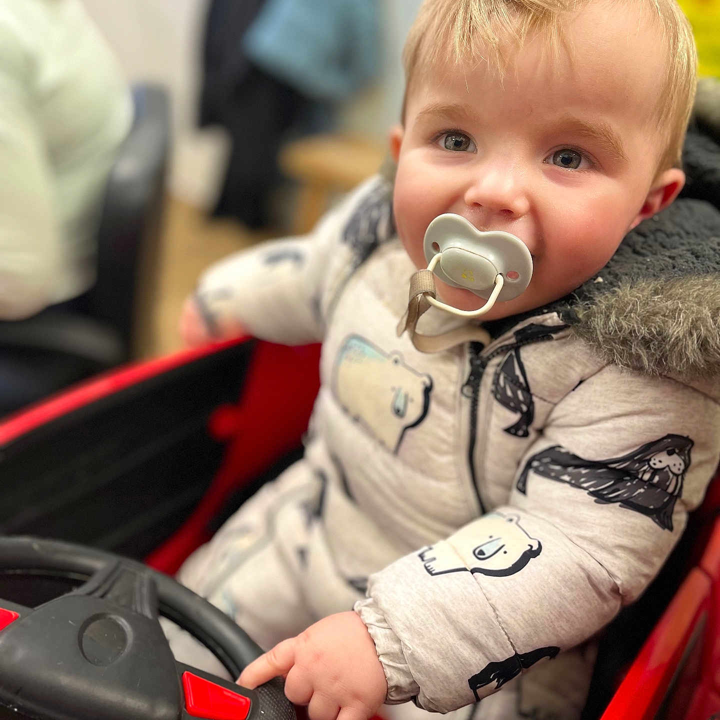 Reuben is registered to the contest to win money with this photo: baby, blonde, bodypart, boy, child, clothing, coat, face, finger, hair, hand, head, jacket, male, person, photography, portrait, sitting, transportation, vehicle