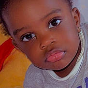 Samuella participe au concours pour gagner de l'argent avec cette photo : child, toddler, face, eyes, hair, earrings, blanket, pillow, clothing, indoor, portrait, curious, soft_texture, cute, baby, skin, young, resting, expression, closeup