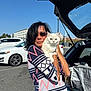 accessory, animal, blue_eyes, car, casual_clothing, cat, daytime, holding, open_trunk, outdoor, parking_lot, patterned_sweater, person, pet, road, sunglasses, sunny, transportation, white_cat, woman