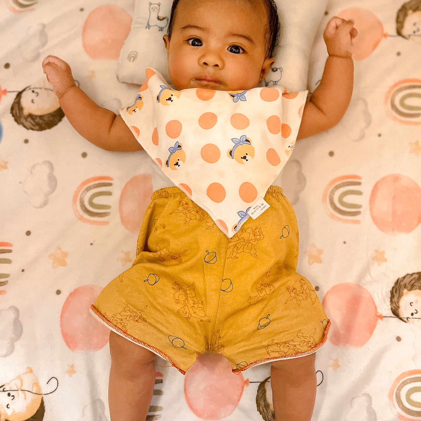 Sky Livia is registered to the contest to win money with this photo: arms, baby, bib, blanket, child, clothing, colorful, cute, expression, face, head, indoors, infant, legs, lying_down, patterned_blanket, polka_dot, portrait, shorts, soft_lighting