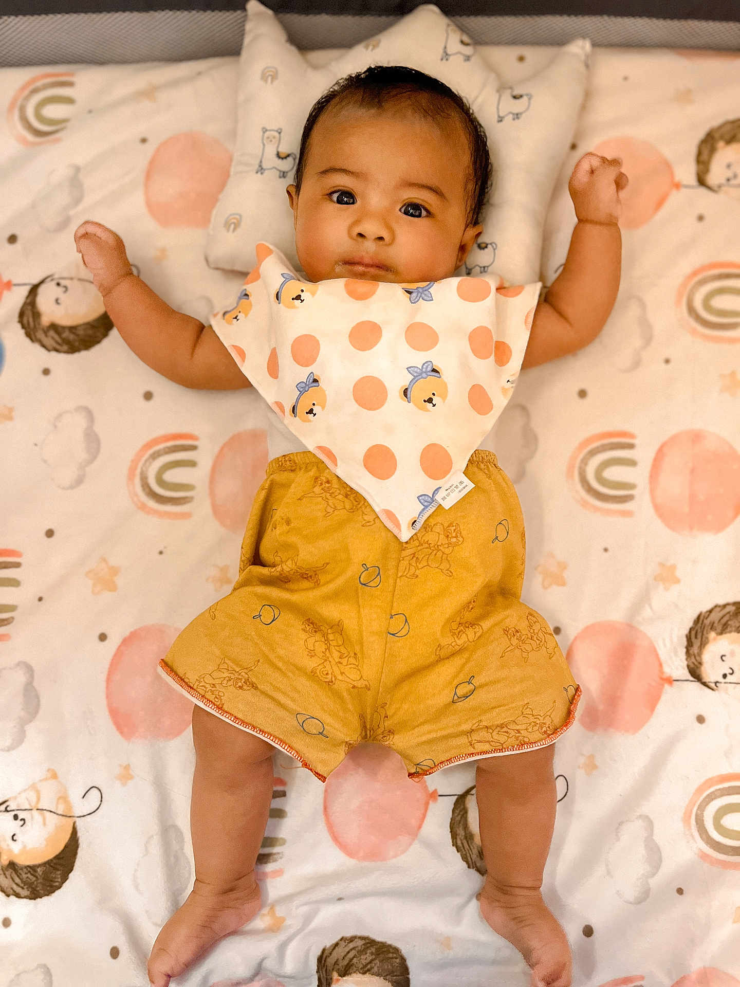 Sky Livia is registered to the contest to win money with this photo: baby, infant, child, blanket, polka_dot, bib, shorts, lying_down, cute, indoors, patterned_blanket, face, arms, legs, head, expression, soft_lighting, colorful, clothing, portrait