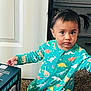Raya is registered to the contest to win money with this photo: box, carpet, child, clothing, crawling, curious, dinosaur_print, door, expression, floor, hair, home, indoor, pajamas, person, pigtails, room, toddler, toy_box, young_child