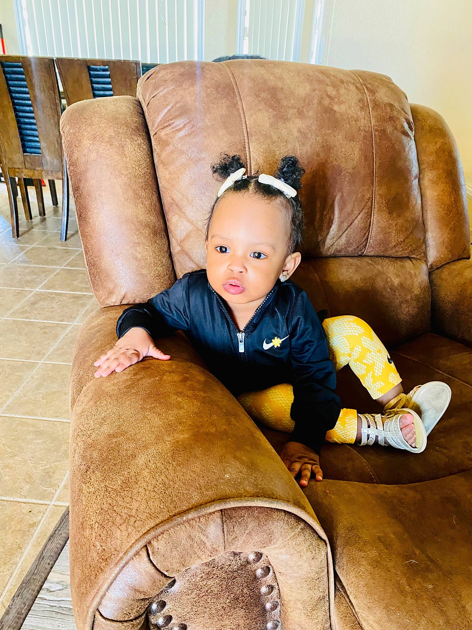 Nomi is registered to the contest to win money with this photo: baby, baby_toddler_clothing, chair, child, comfort, couch, flooring, fur, hardwood, human_leg, living_room, person, room, sitting, sleeve, toddler, wood