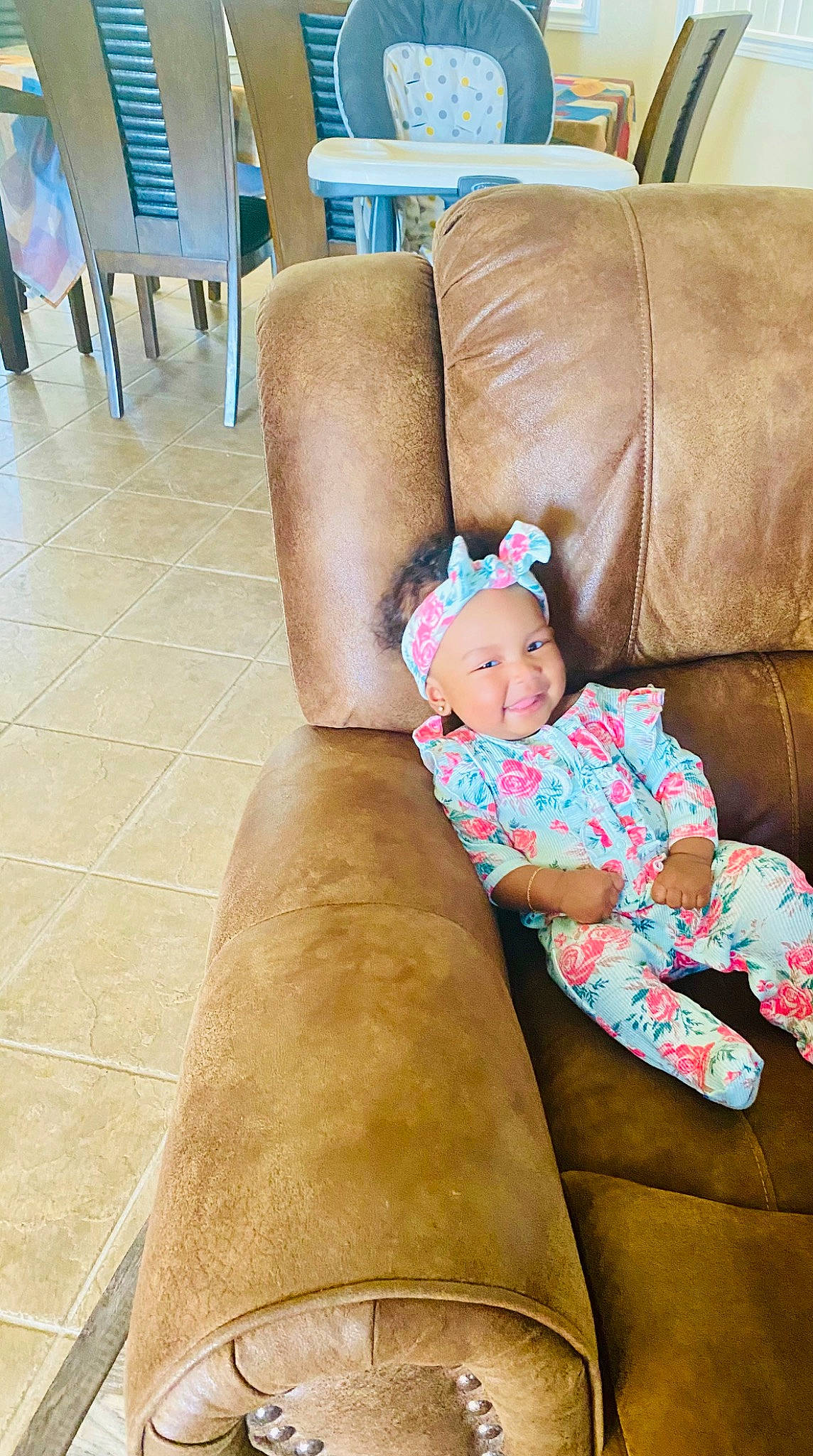 Nomi is registered to the contest to win money with this photo: baby, baby_toddler_clothing, blond, child, comfort, couch, eye, fawn, floor, flooring, hardwood, headwear, human_leg, knee, lap, living_room, person, room, sitting, thigh