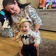 Damien participe au concours pour gagner de l'argent avec cette photo : bow_tie, cabinet, child, clothing, floor, happy, hat, home, indoor, pants, person, rug, shirt, shoes, smiling, suspenders, television, toddler, woman, wooden_floor