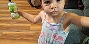 Emberlynn joined the competition — help win amazing prizes! bottle, child, clothing, couch, curious, dress, expression, floor, furniture, girl, hair, indoors, living_room, minnie_mouse, person, pigtails, toddler, toy, wooden_floor, young_child