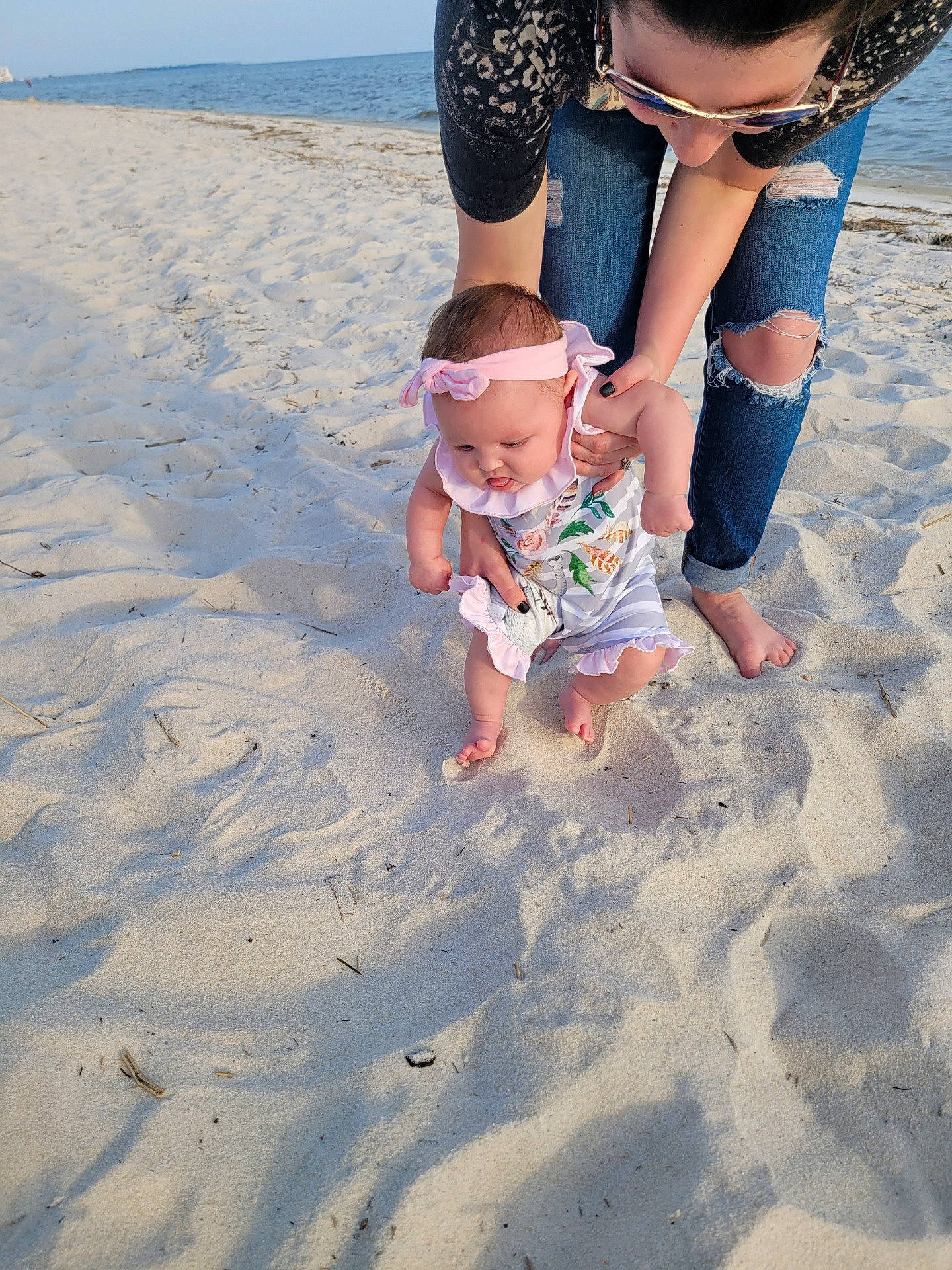Raelynn is registered to the contest to win money with this photo: azure, barefoot, beach, blue, body_of_water, foot, fun, gesture, happy, headwear, morning, natural_environment, people_in_nature, people_on_beach, person, photograph, sand, shorts, sky, summer