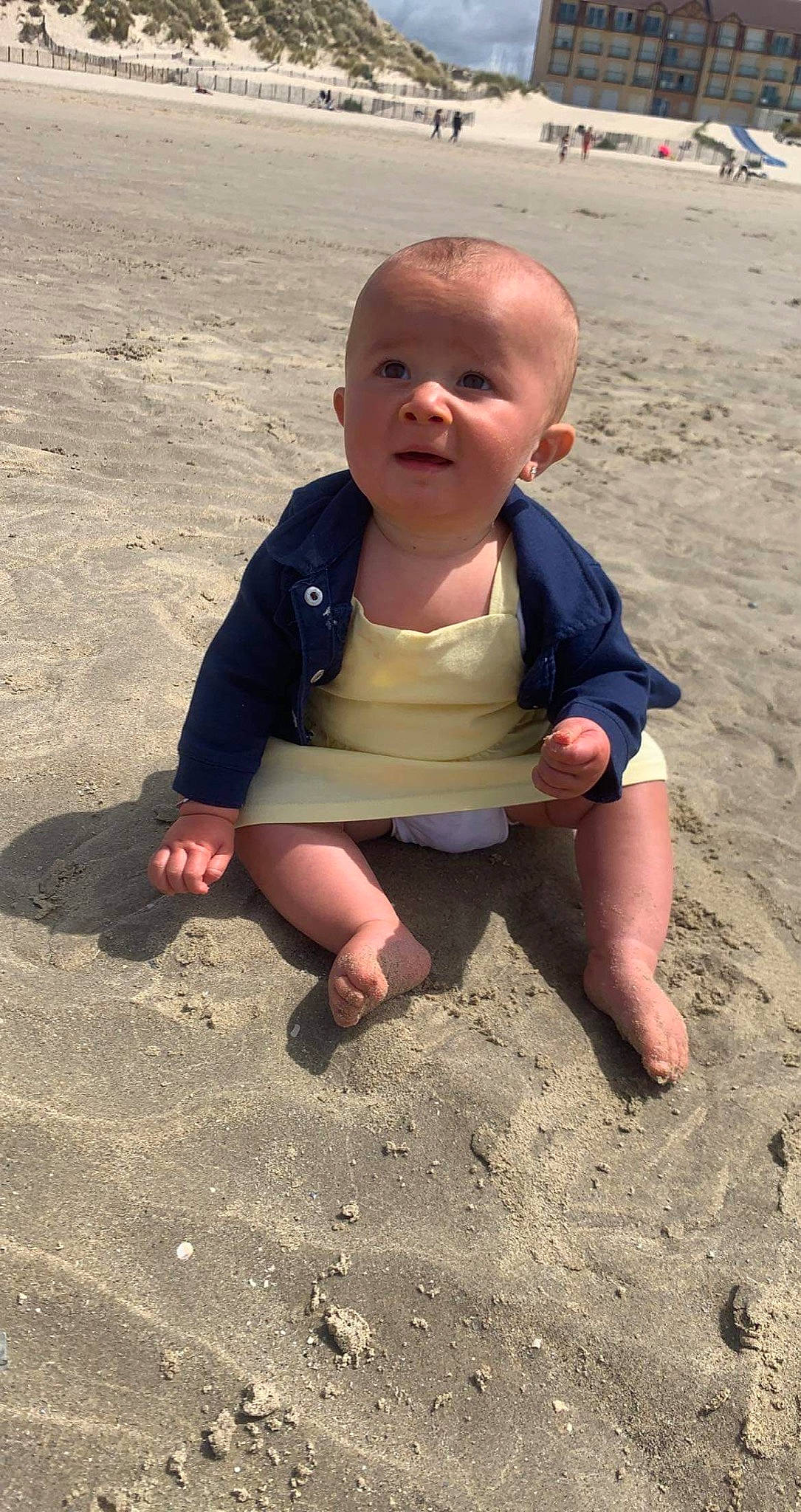 Noelani participe au concours pour gagner de l'argent avec cette photo : baby, baby_toddler_clothing, barefoot, beach, body_of_water, child, finger, foot, fun, happy, head, mouth, people_in_nature, people_on_beach, person, sand, sitting, smile, soil, thumb